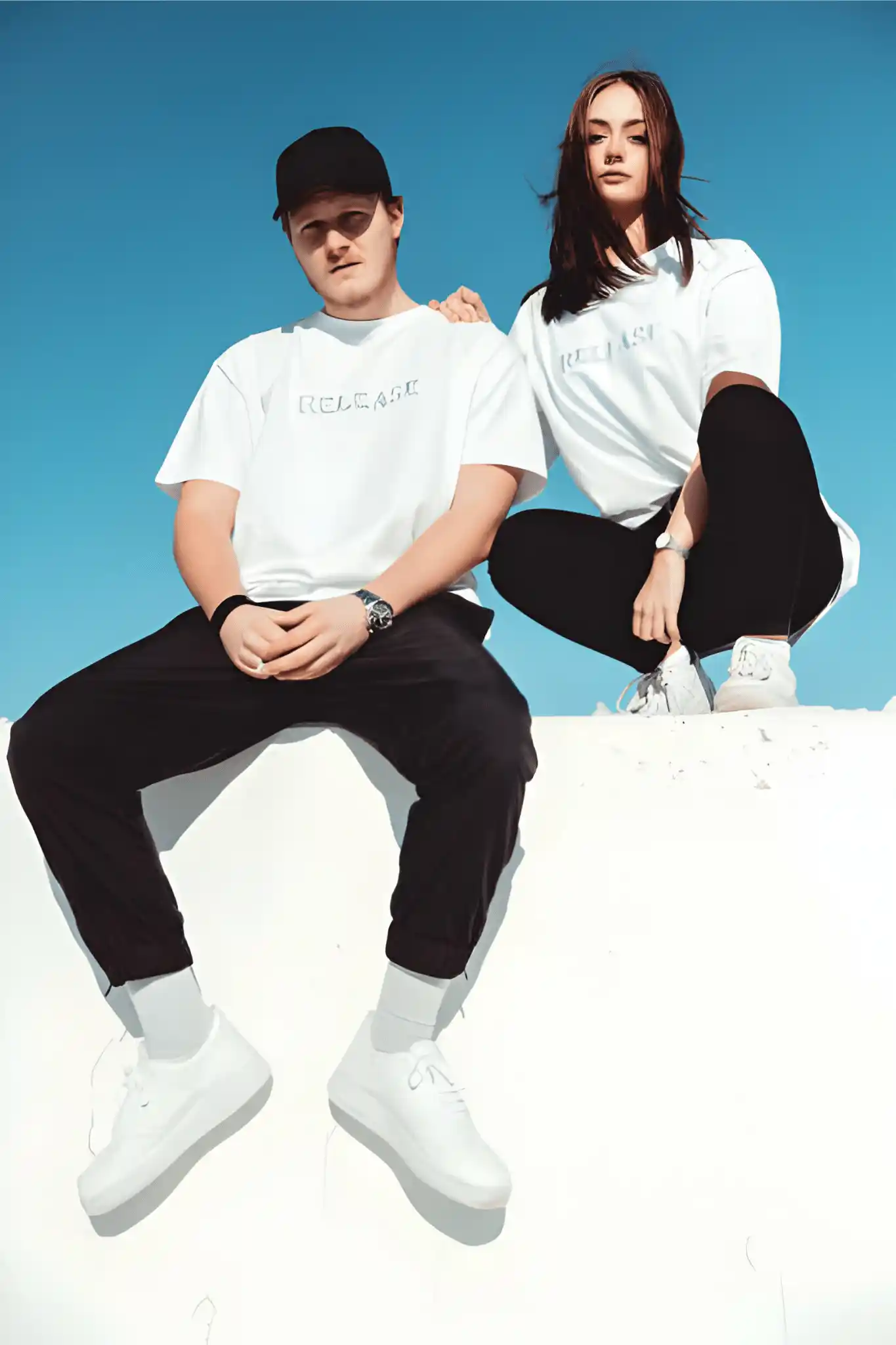 A young man and a girl wearing white T-shirts are sitting.